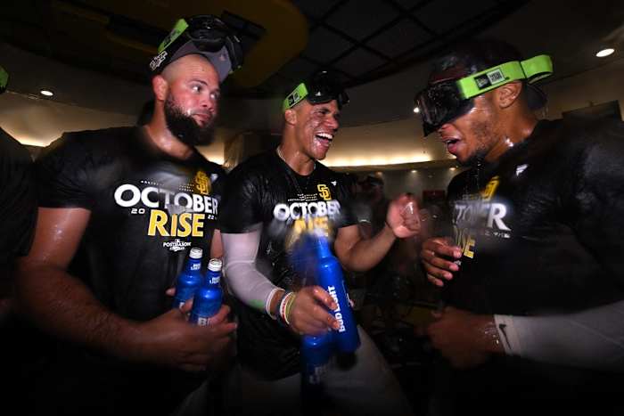 The Padres clinched a playoff spot after the Brewers lost to the Marlins. Juan Soto (center) celebrates in Luis Garcia (left) and Jose Azocar (right).